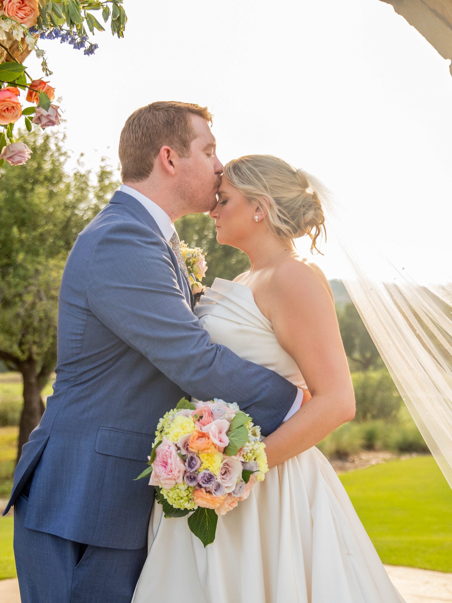 Jason and Carly embracing at golden hour in an open Texas Hill Country field