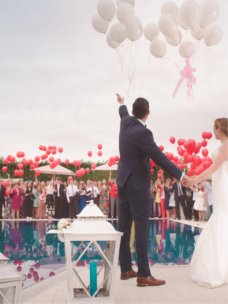 Guests releasing balloons beside the pool as Lauren and David celebrate