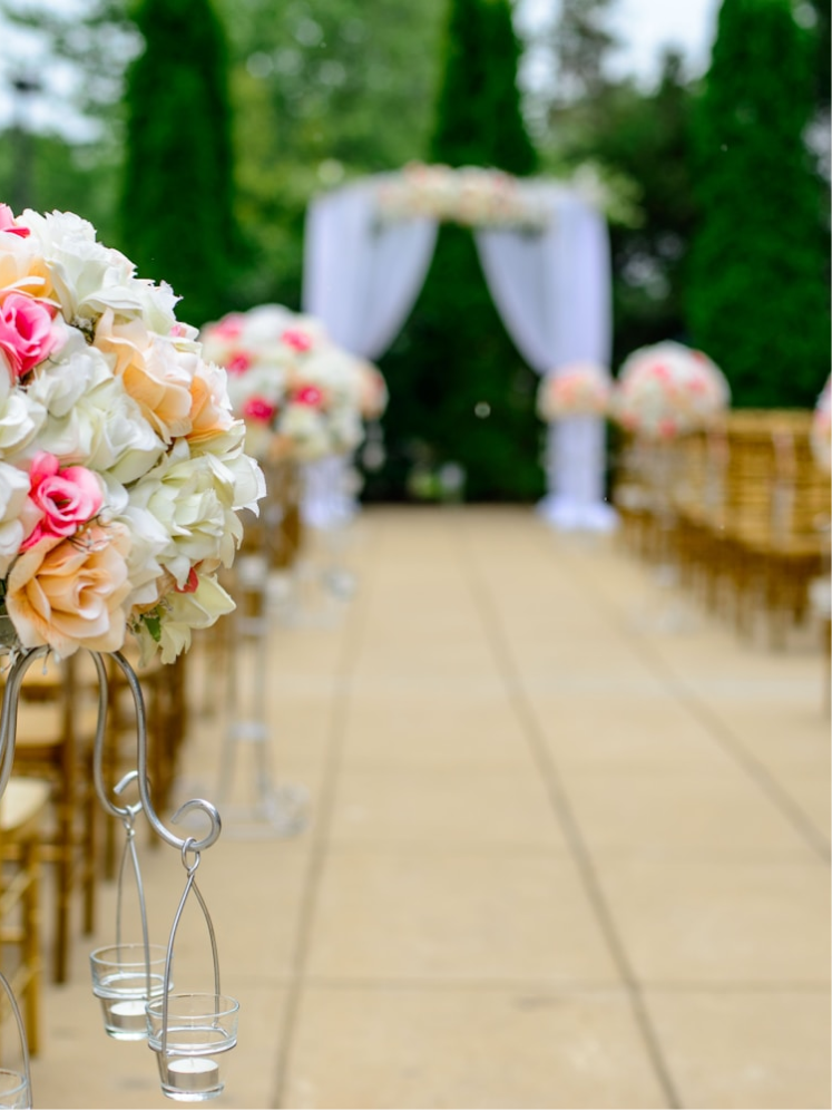 Floral aisle lined with gold chairs leading to the ceremony arch