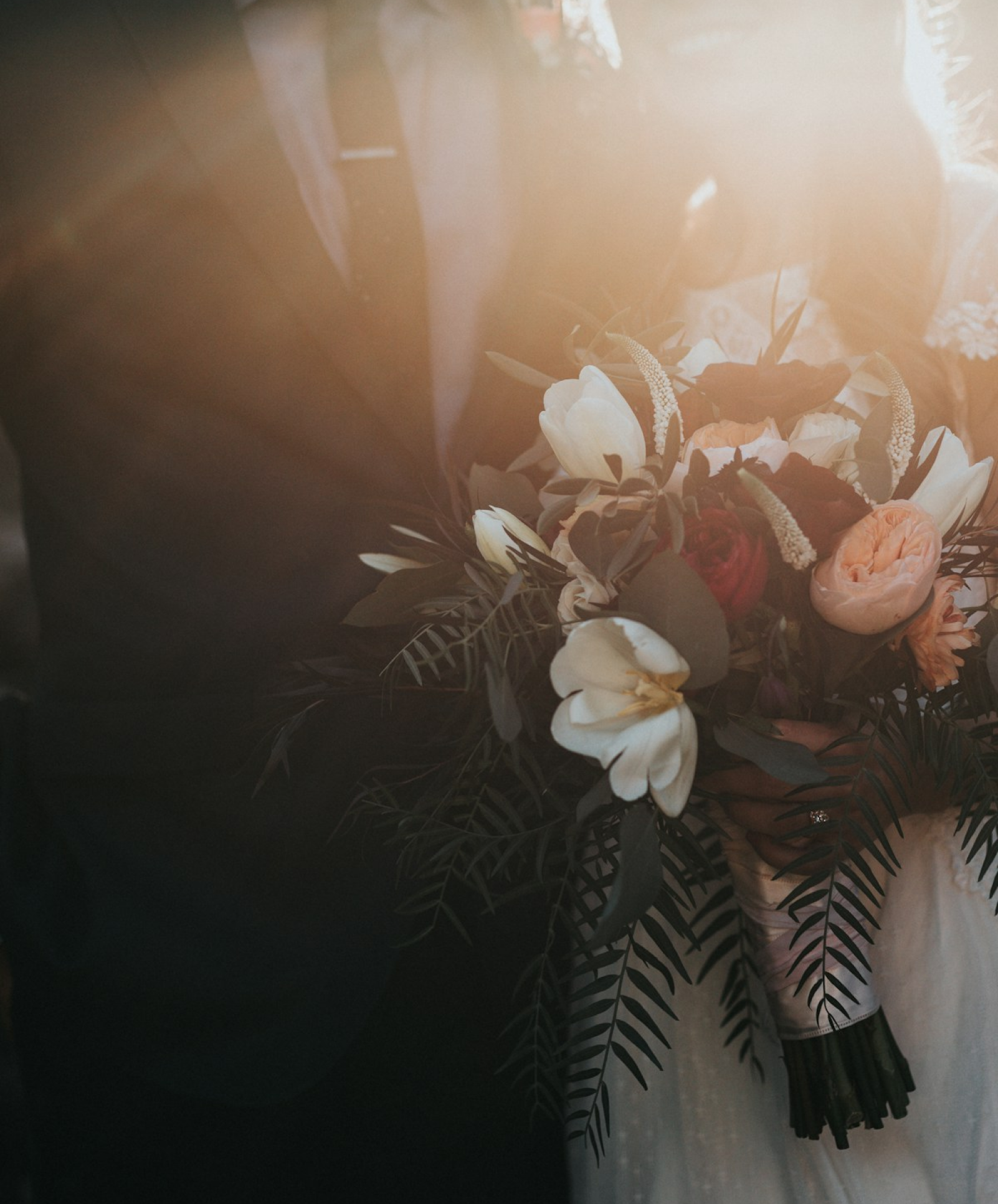 A bride in her dress, photographed from behind in soft daylight